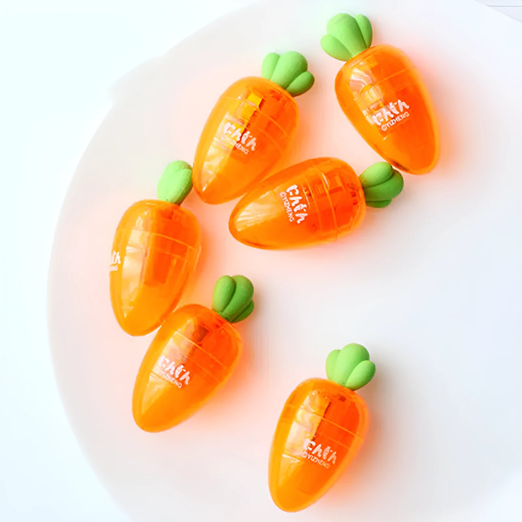 Carrot-shaped orange plastic pencil sharpener with green top, showing compact size next to pencil