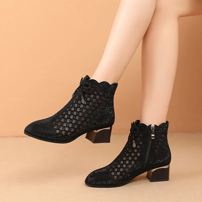 Women's black cutout mesh ankle boots with mid heel and rhinestone trim, side zipper closure