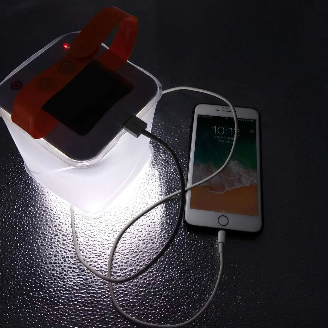 White solar inflatable waterproof camping LED lantern with handle, collapsed flat on a table