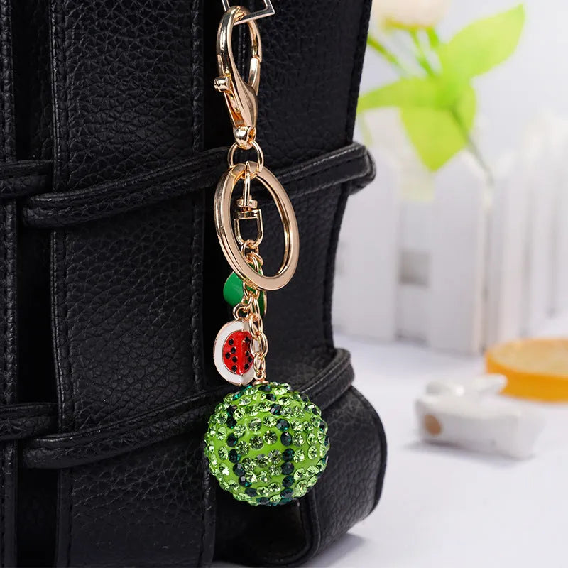 Green watermelon-shaped zinc alloy keychain with decorative accents, shown on a key ring.