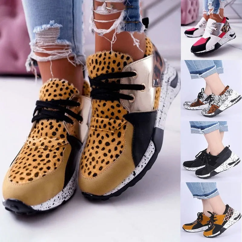 Women's black suede casual sneakers with a wedge heel on a wooden floor.