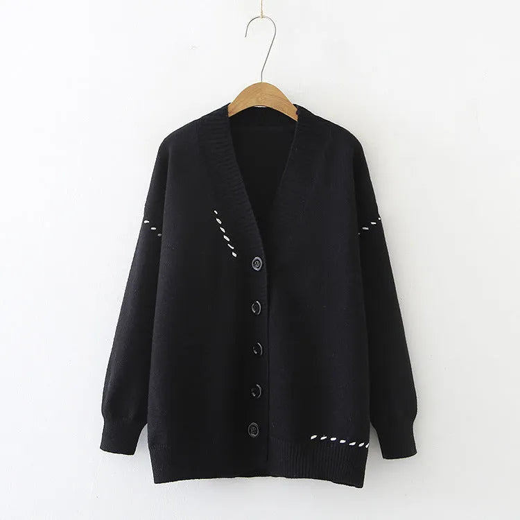 A women's loose-fit knitted cardigan coat in black, showing long sleeves and a solid colour design.