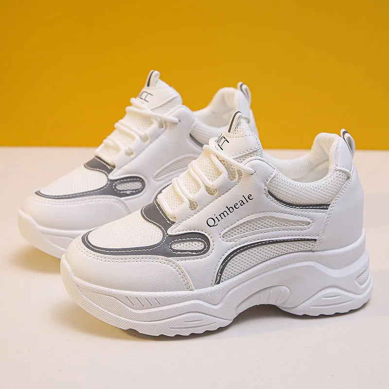 White height increasing dad shoes with mesh upper and wedge heel on a neutral background