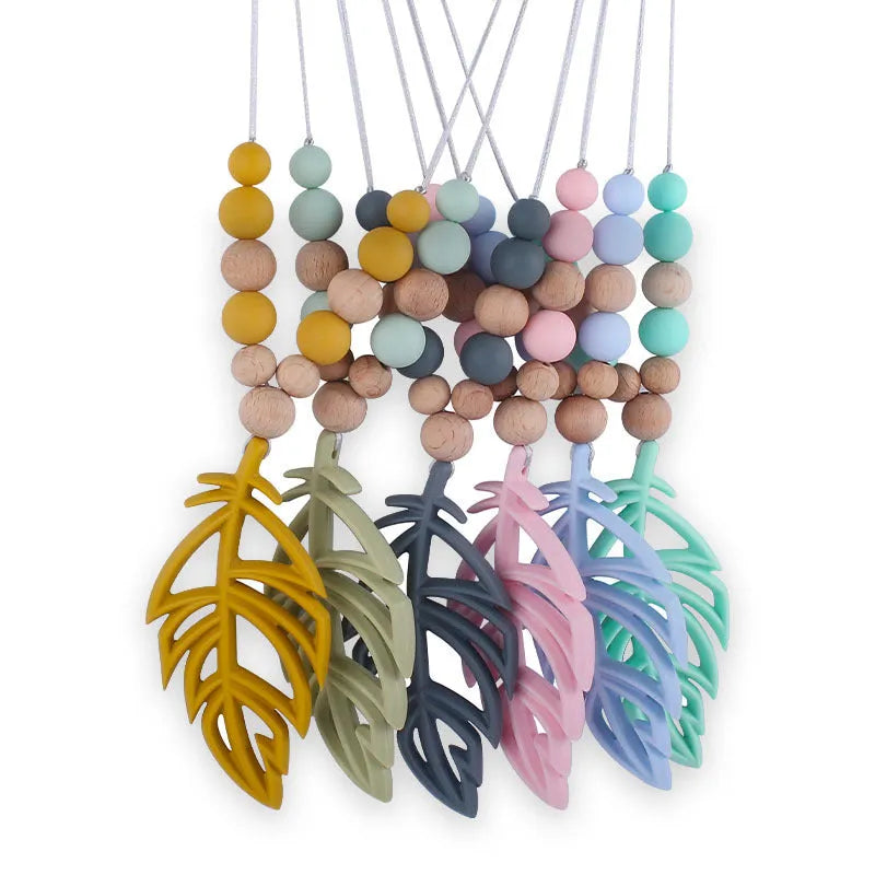 Silicone leaf teether necklace for babies over 3 months, about 35g, shown in mint green, bean green, pink, grey, turmeric, and blue