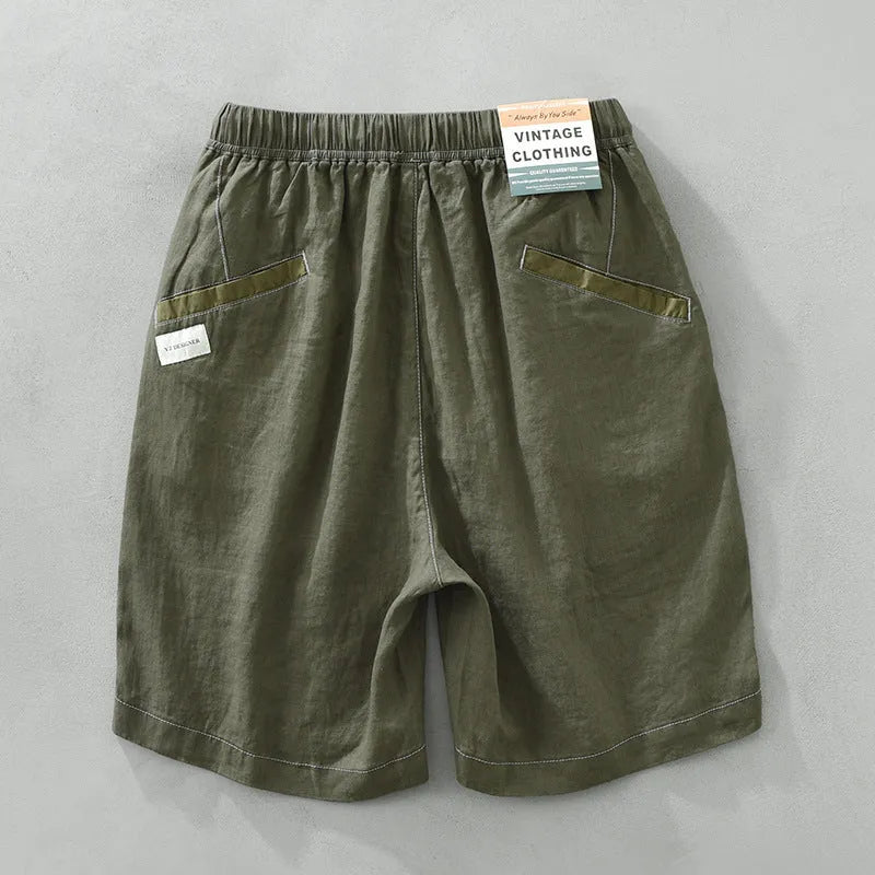 Men's loose fit linen shorts in green on a neutral background