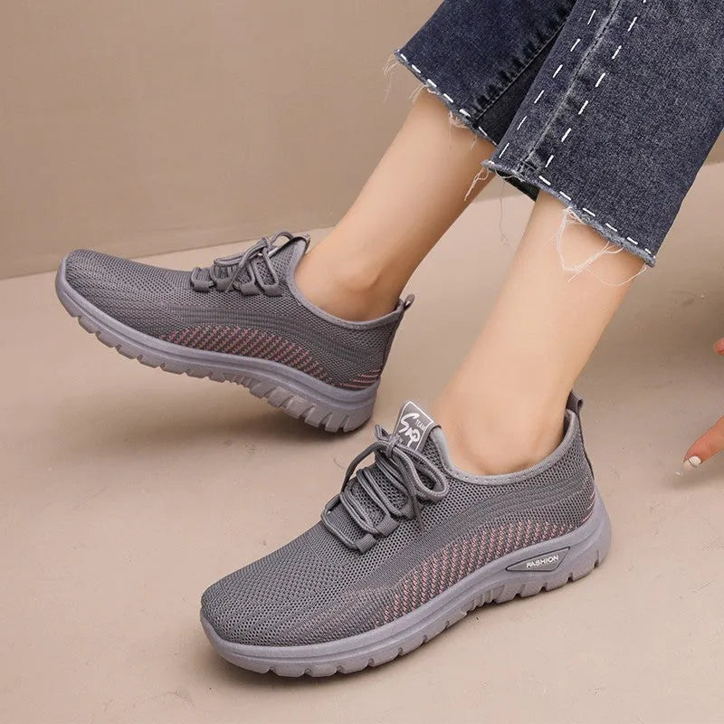 Women's low-top mesh sneakers in black, gray, or purple with round toe, cross straps, and rubber sole.