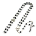 Black hematite rosary necklace with zinc alloy cross and triangle on dark background
