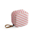 Blue cloth cube-shaped makeup storage bag on a table.