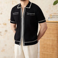 Slim fit black knitted polo shirt with a lapel collar and short sleeves on a hanger.