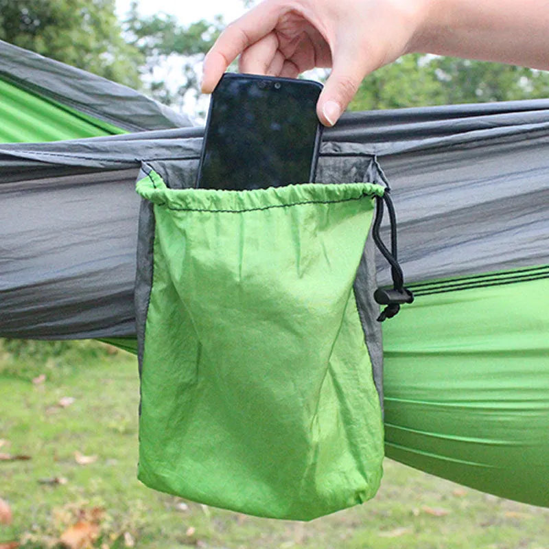 Blue nylon parachute cloth camping hammock hung between two trees outdoors