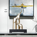 Fortune Bring Elephant decorative resin statue in gold on a wooden shelf.