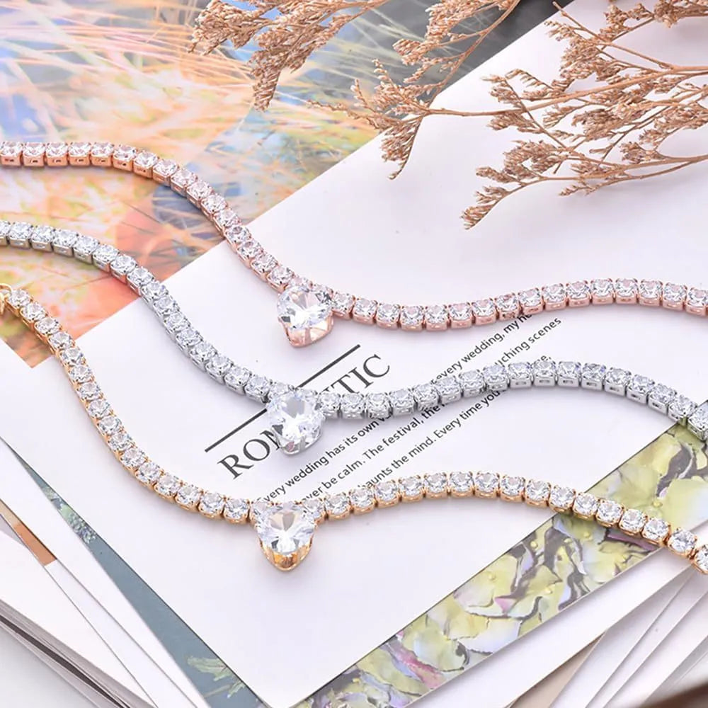 Shiny rhinestone heart-shaped collar for dog or cat in gold, on a size chart showing S, M, L measurements.