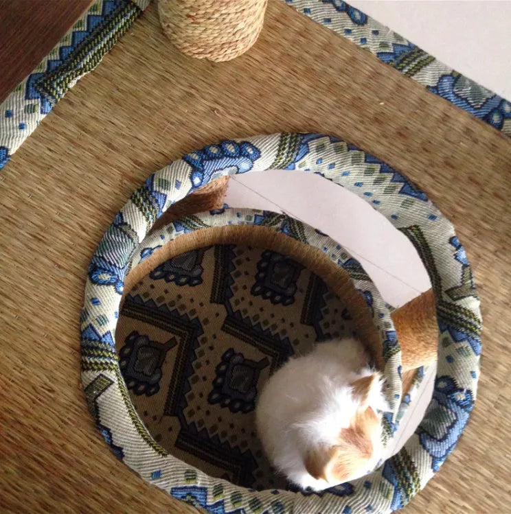 Cat playing on a natural wheat straw scratch board climbing frame with multiple levels