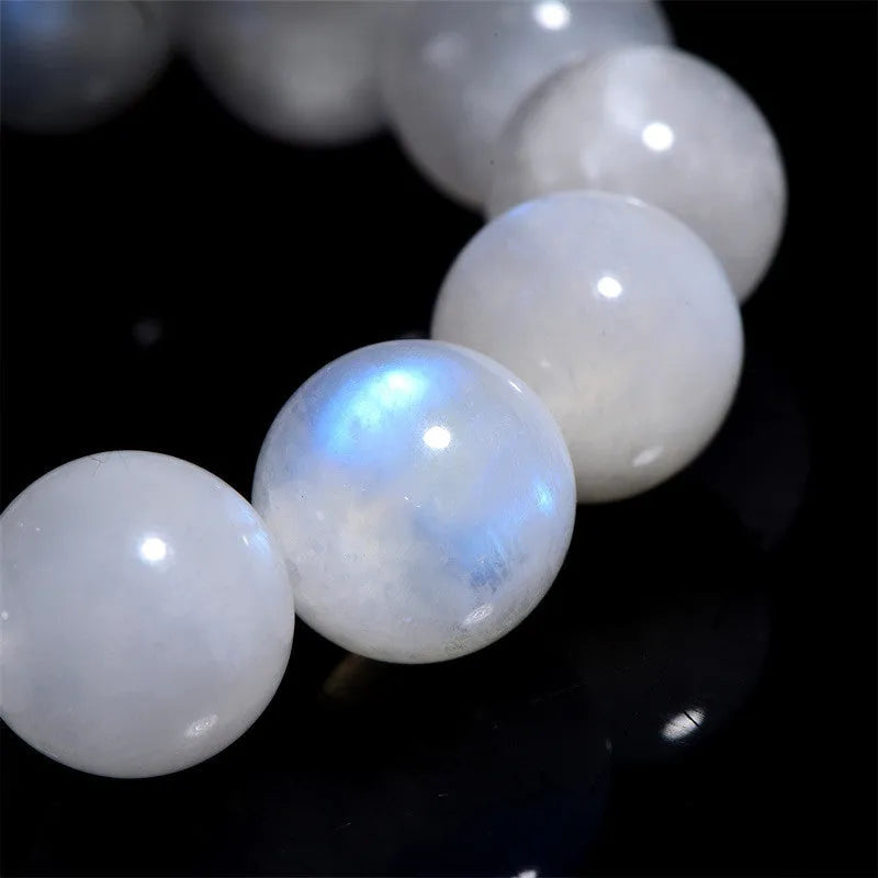 Natural white Moonstone round bead bracelet on a wrist, showing polished geometry beads.