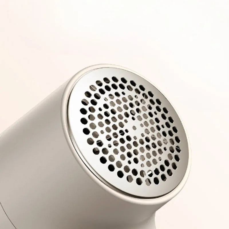 White USB rechargeable electric lint remover and fabric shaver with LED display on a grey background.
