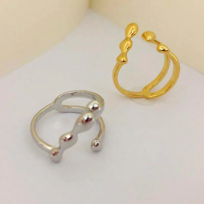 Adjustable brass ring with sphere design in gold or silver plating.