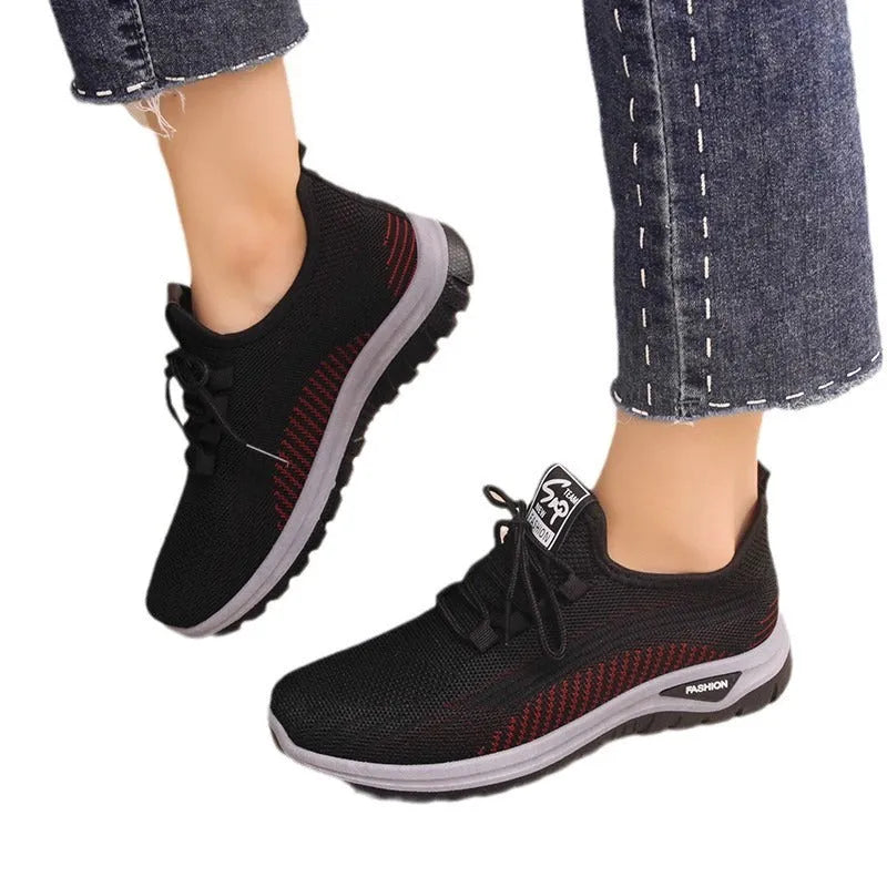Women's low-top mesh sneakers in black, gray, or purple with round toe, cross straps, and rubber sole.
