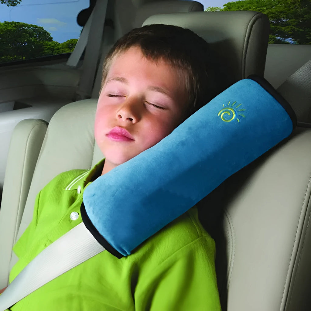 Children car pillow in grey micro-suede fabric attached to a car seat belt shoulder strap