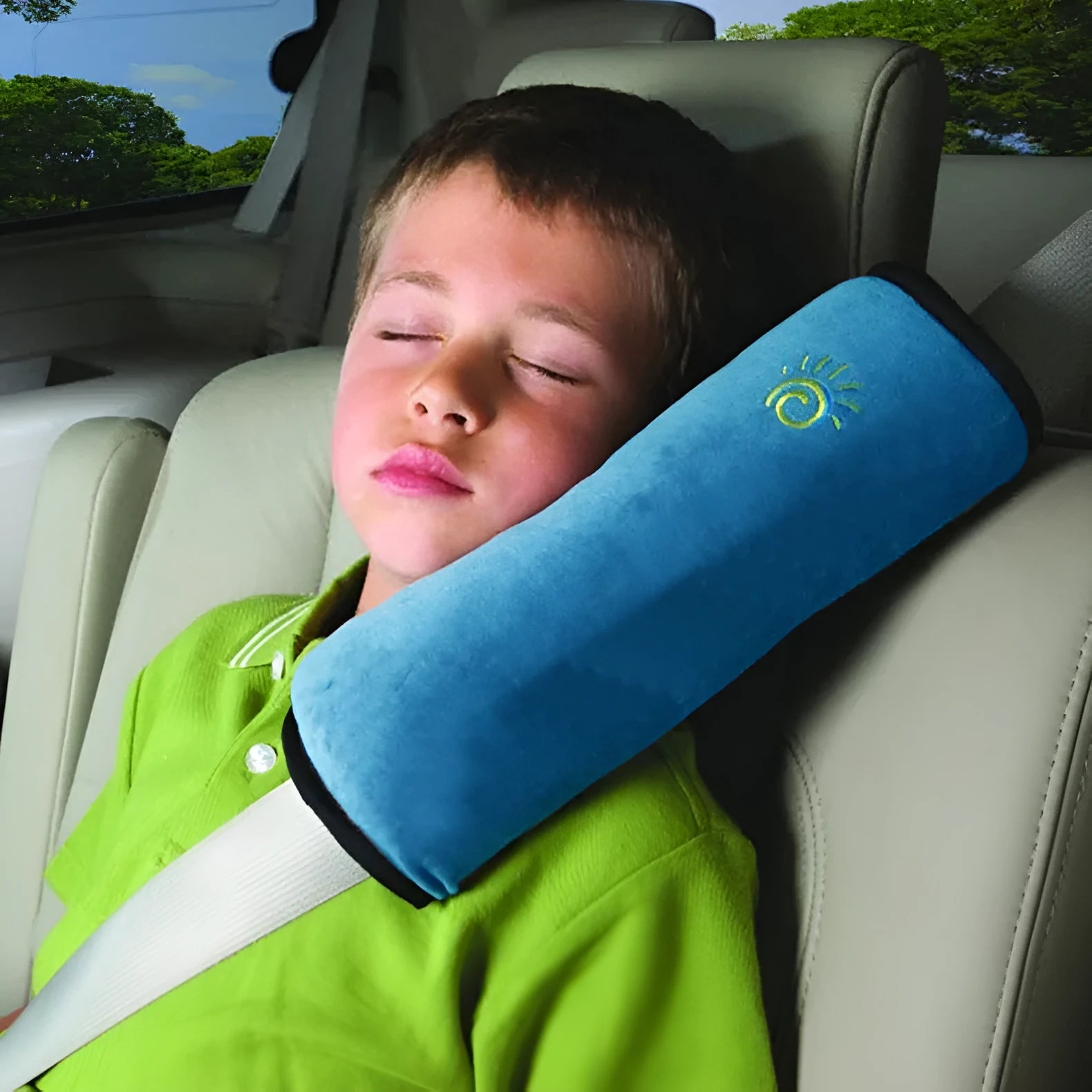 Children car pillow in grey micro-suede fabric attached to a car seat belt shoulder strap