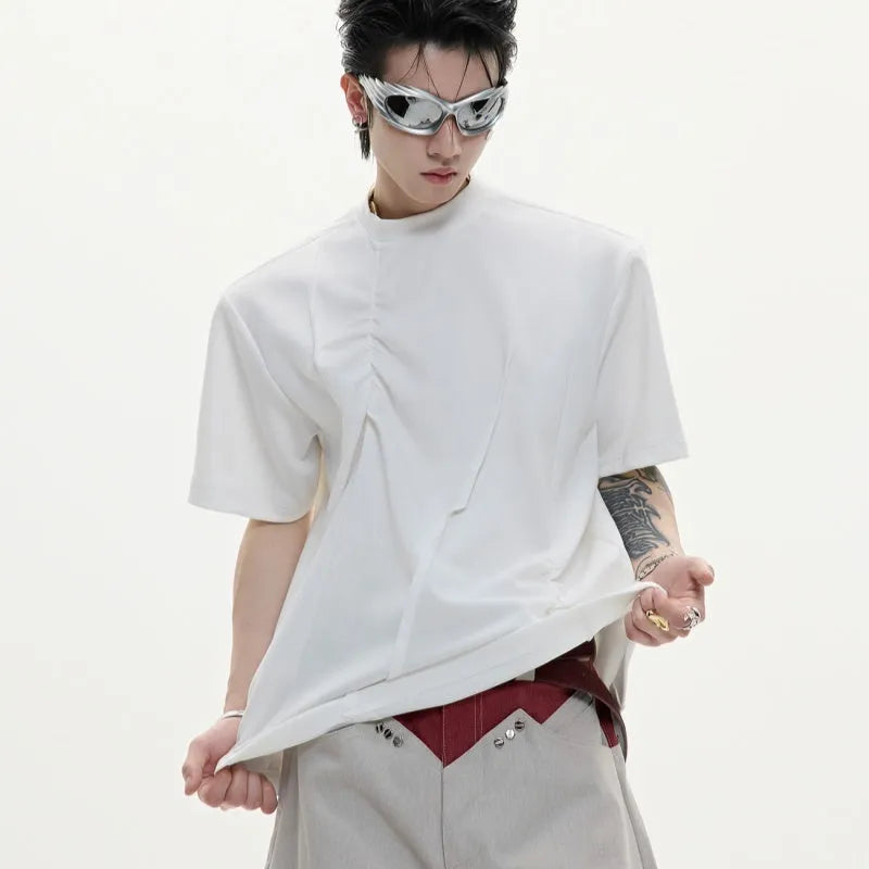 Men's loose black cotton T-shirt with textured pleats and asymmetric design detail.