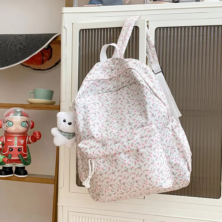 Japanese-style floral print girls' backpack in Oxford cloth with curved shoulder straps, shown in pink floral or white tulip scarf bear.