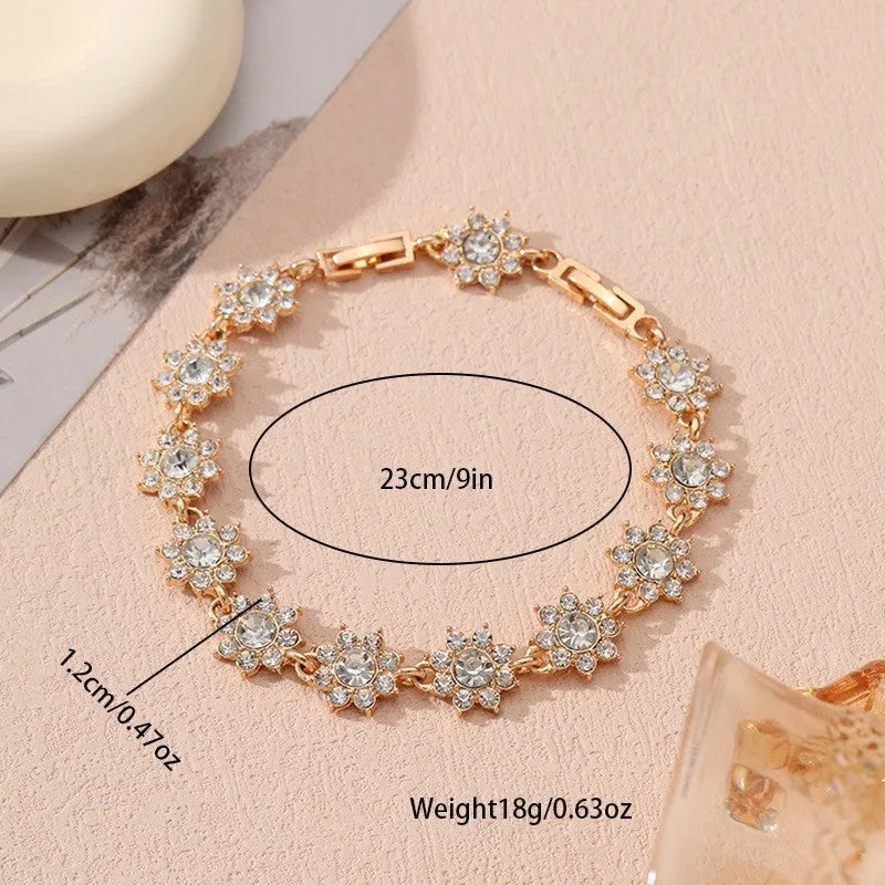 Electroplated zinc alloy flower bracelet with coloured crystals in gold or silver finish.