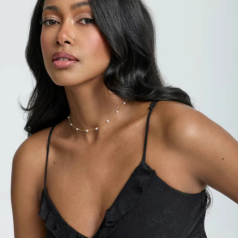 Pearl necklace with copper geometric pendant and ball bead chain on dark background
