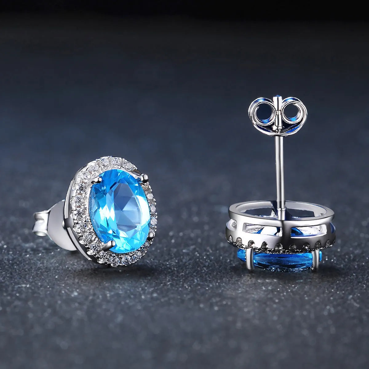 Four-piece sterling silver jewellery set with blue topaz: geometric earrings, ring, pendant, and necklace.