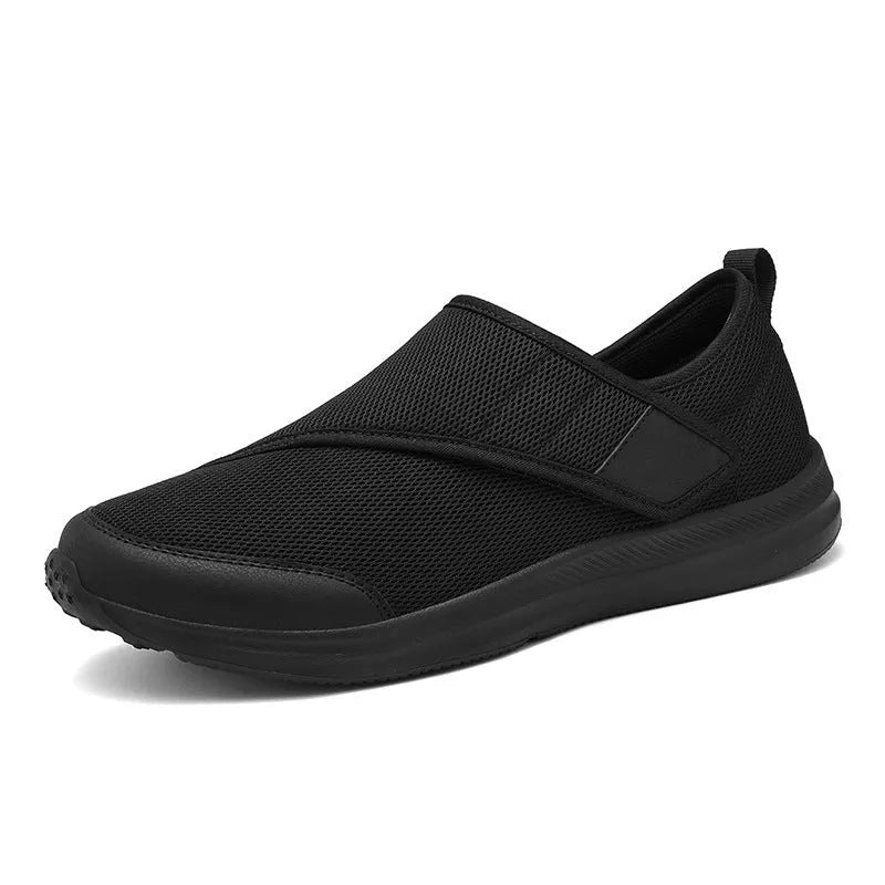 A pair of grey mesh walking shoes with a Velcro strap closure, shown on a white background.