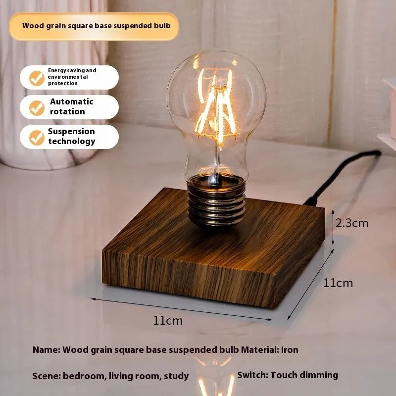 Creative small iron suspension bulb night lamp on a black woodgrain base for desktop decoration.