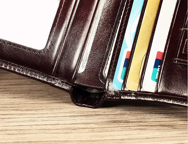 Men's black leather wallet open to show internal card slots, coin pocket, and banknote compartment.