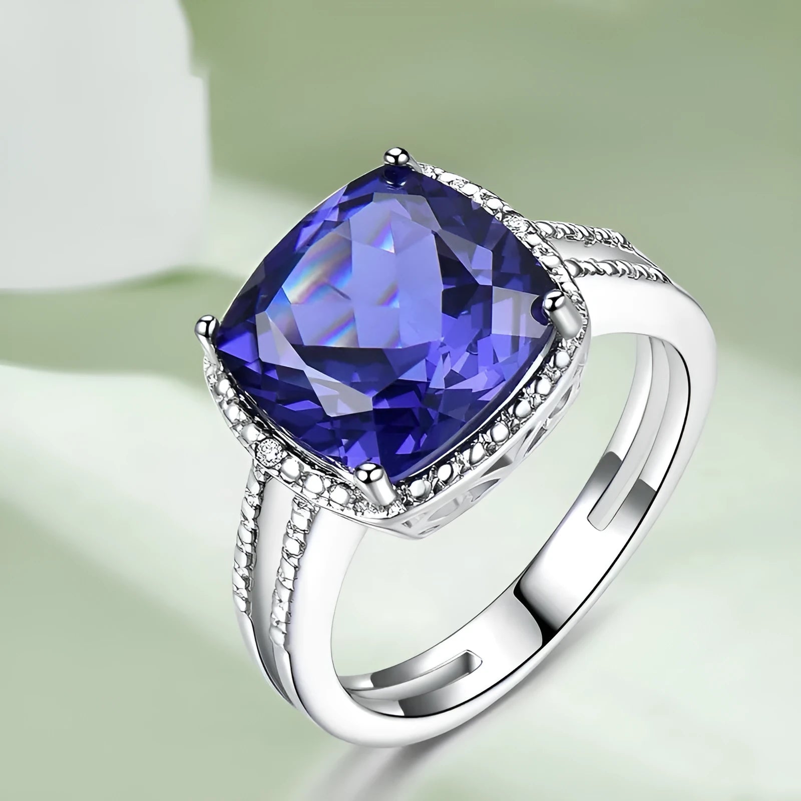 Blue tanzanite stone set in a sterling silver women's ring on a grey background.