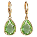 Copper and glass water drop earrings with a carved Saturn ring design in a geometric shape.