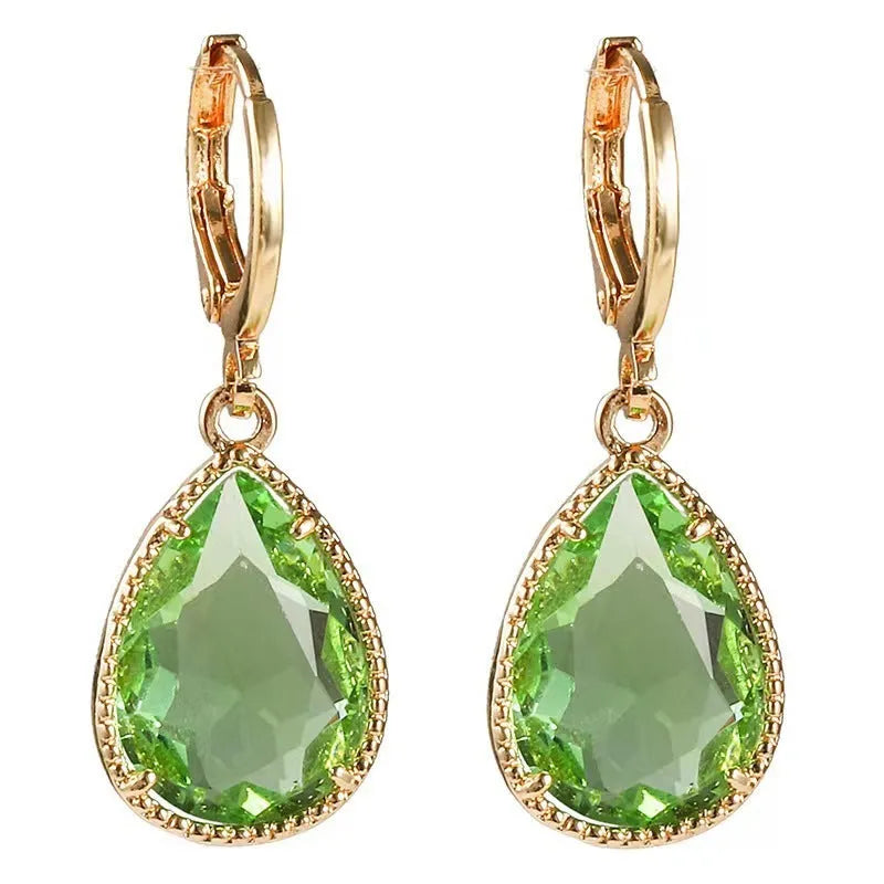 Copper and glass water drop earrings with a carved Saturn ring design in a geometric shape.