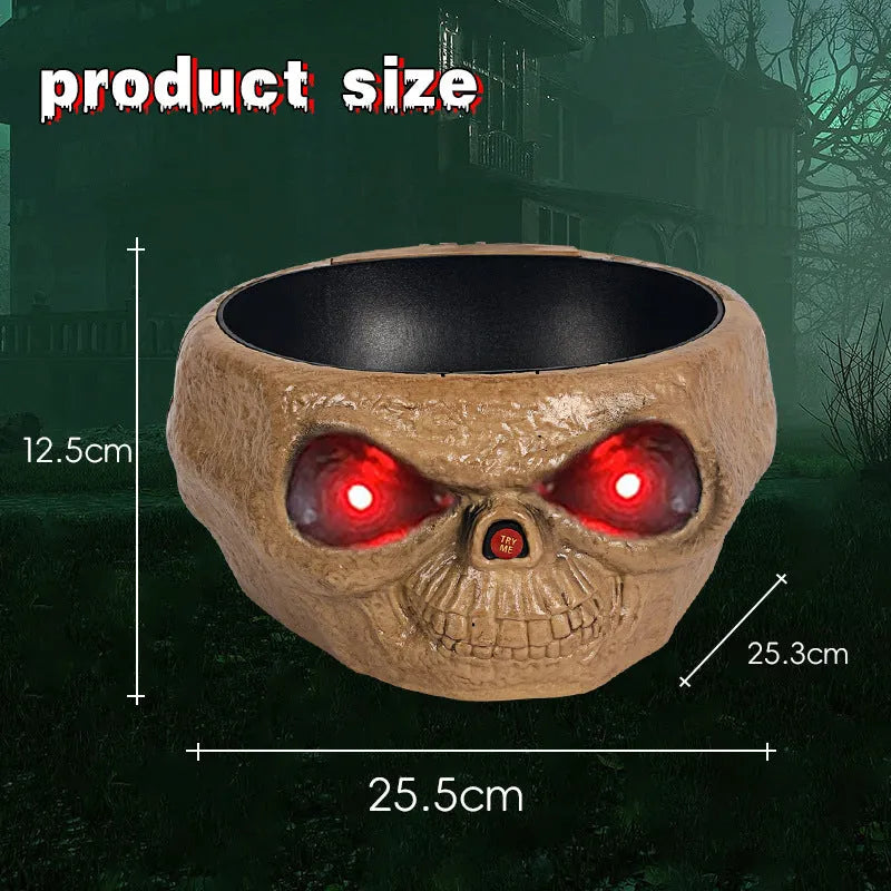Plastic Halloween pumpkin candy bowl with motion activated skeleton hand, glowing red eyes, in Khaki colour, on a table with candy.