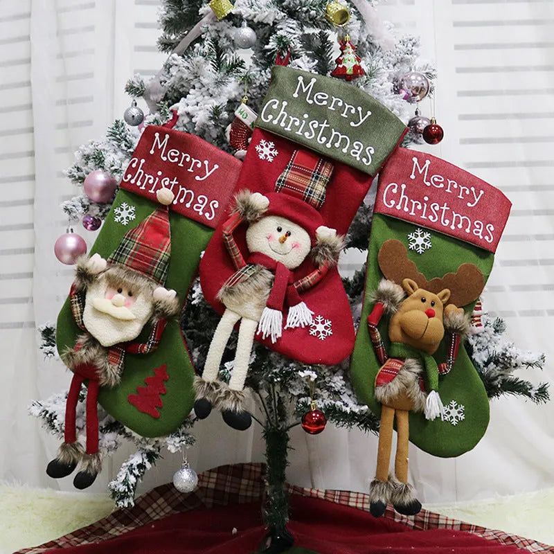 Three large Christmas stockings with 3D Santa, snowman, and reindeer designs hung on tree