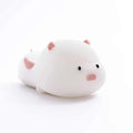 Blue silicone pig-shaped rechargeable LED night light with touch control on a wooden surface.