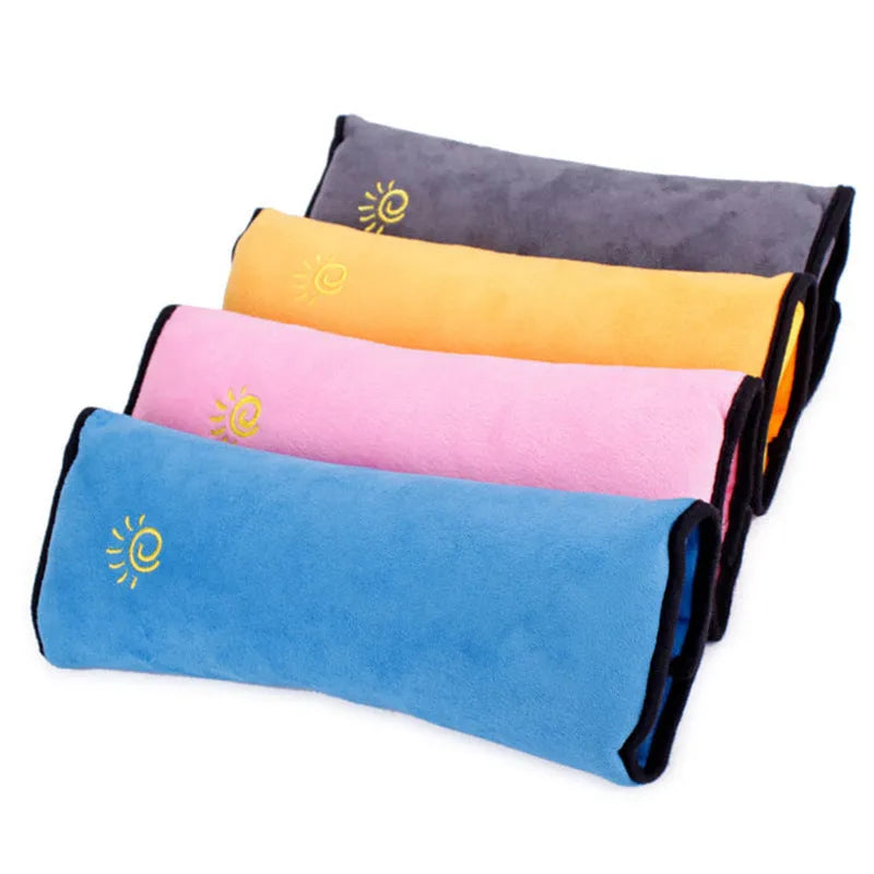 Children car pillow in grey micro-suede fabric attached to a car seat belt shoulder strap