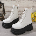 Women's black platform Martin boots with patchwork detail and side zip on a white background.