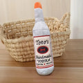 Brown plush dog toy shaped like a wine bottle with a textured surface.