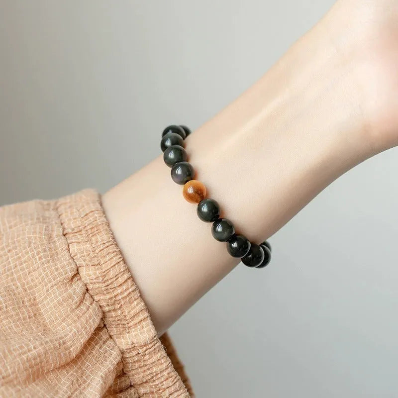Black obsidian geometric bracelet with spherical beads on a wrist, showing unisex Korean style.