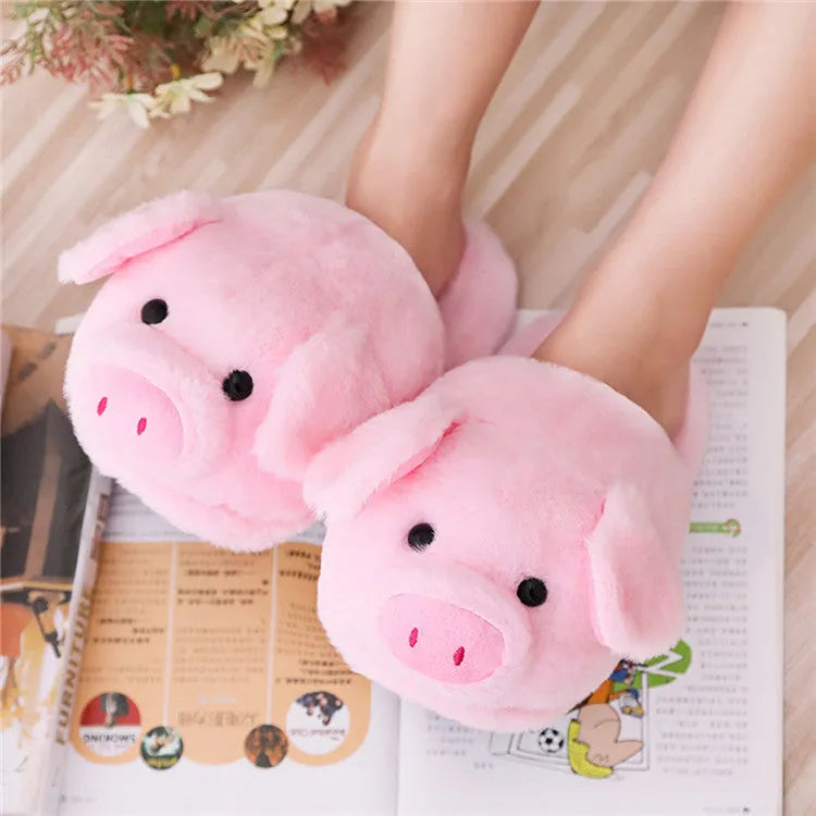 Pink pig-shaped plush indoor slippers with a cute animal face design, shown on a plain background.