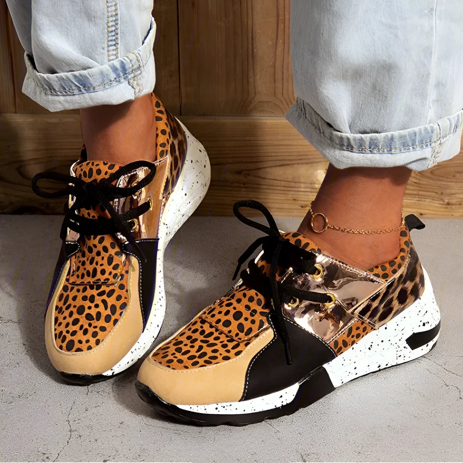 Women's black suede casual sneakers with a wedge heel on a wooden floor.
