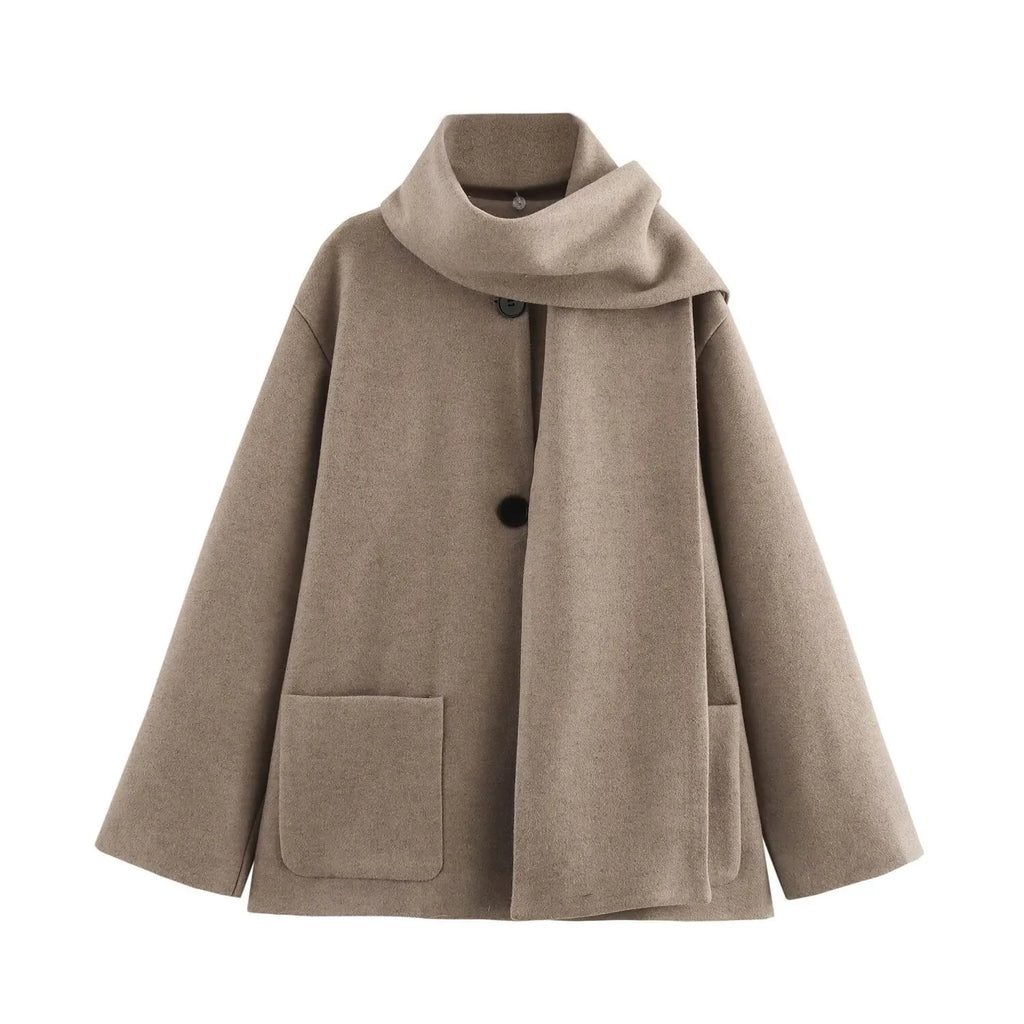 Women's long black overcoat with a grey fur collar and pockets, shown on a model.