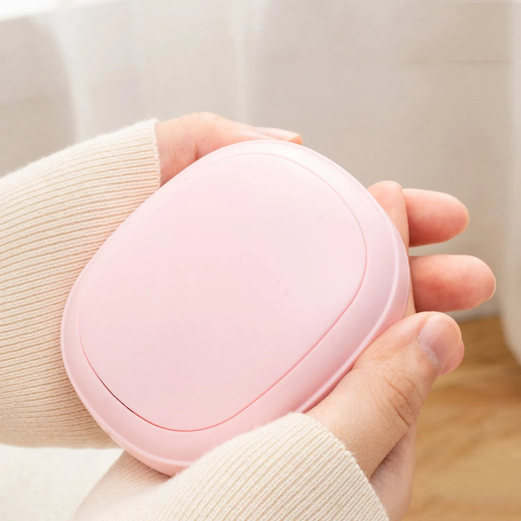 USB hand warmer in pink with three-gear temperature control and compact pebble design