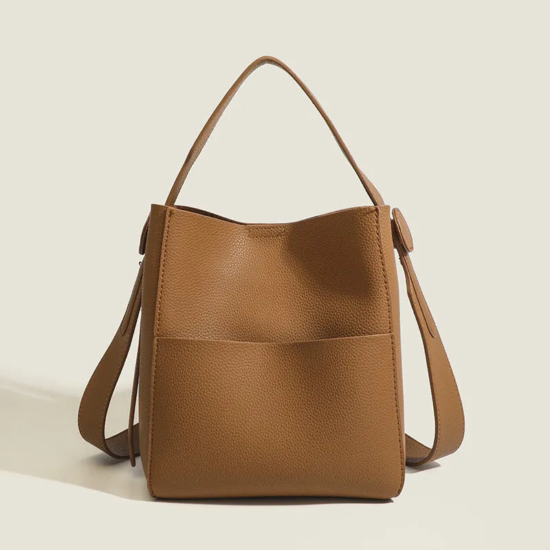 Soft PU bucket messenger bag in elephant gray with visible sewing line detailing, outer sandwich pocket, and single shoulder strap.