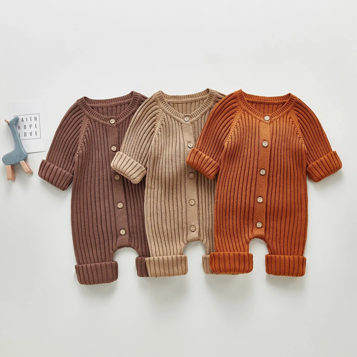 Baby long-sleeved knitted jumpsuit romper pullover in beige, size 80cm, lying flat on a white background