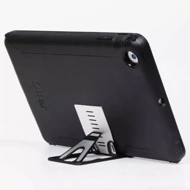 Black card phone holder measuring 8.5cm by 5cm on desktop surface