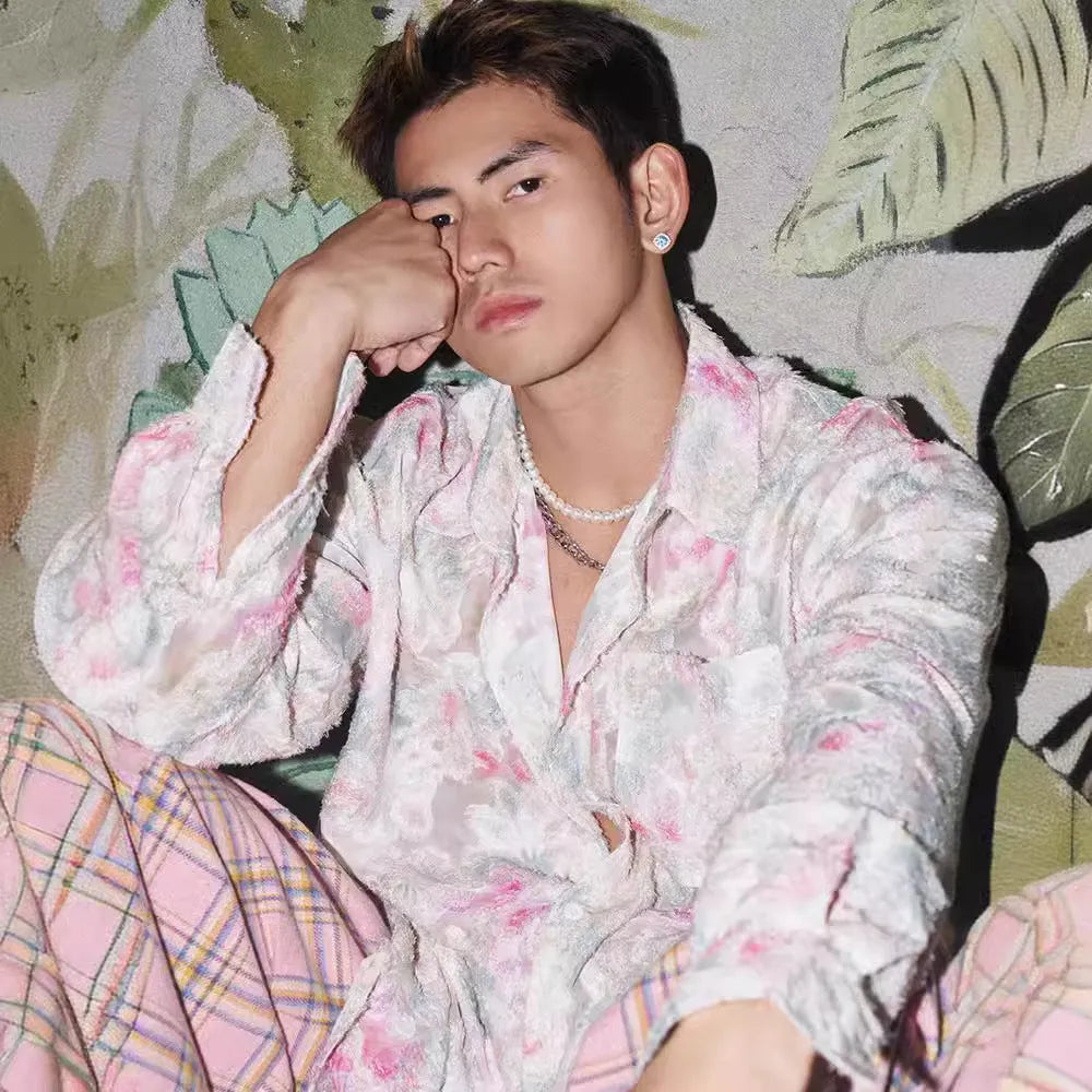 Pink embossed floral pattern long sleeve shirt laid flat, showing loose fit and textured design.