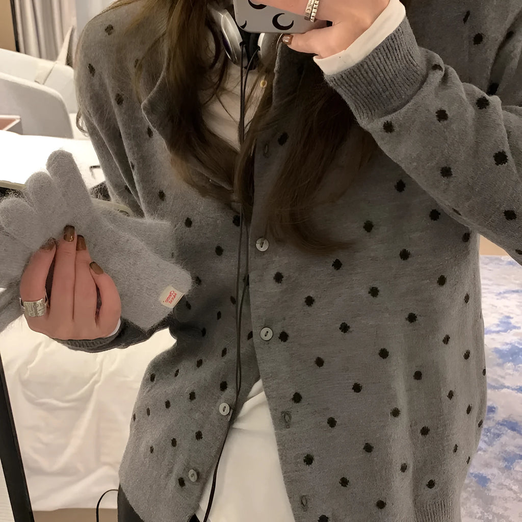 Women's grey loose-fit knitted cardigan with a crocheted flower on the front.